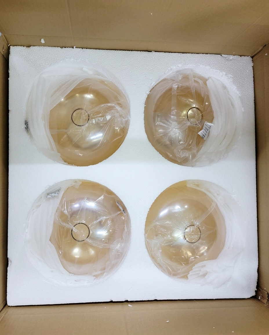 Amber glass shades nested in custom-cut foam trays inside a carton