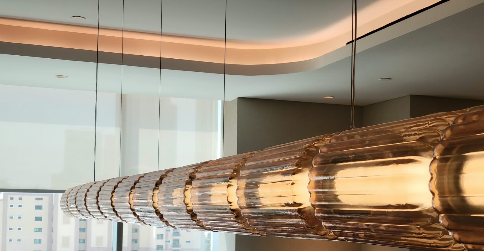 Close view of the fluted tinted glass along a lit linear pendant run