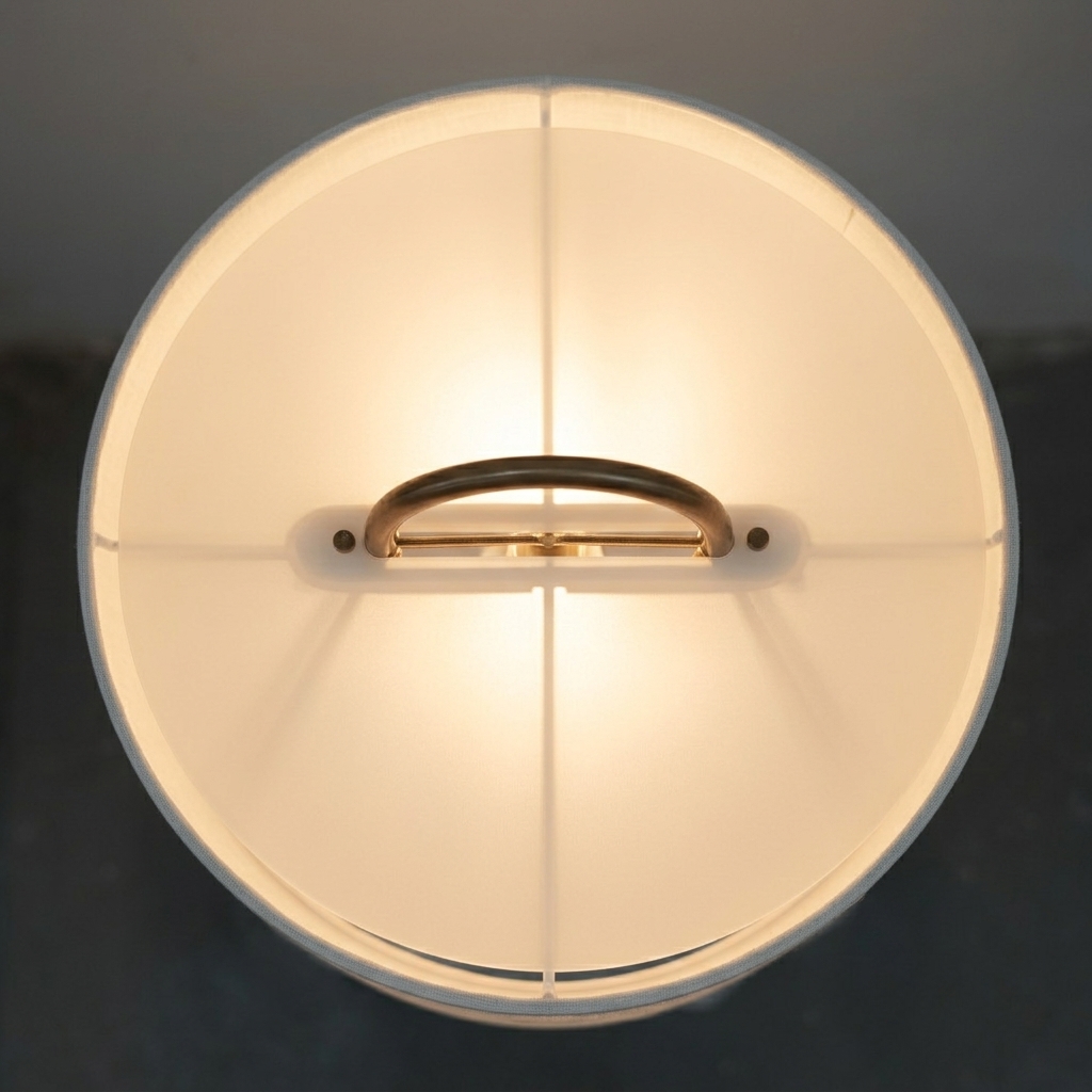 Linen drum shade with copper arch, viewed from above, lit